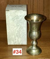 Sterling silver wine cup shown beside its original box on a wooden surface.