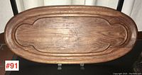Top view of vintage Dansk teak cutting board or tray, showing overall shape, wood grain, and carved detail