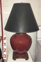 Front view of the vintage pottery table lamp with black shade, showing the lamp turned off.