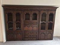 Front view of complete assembled antique style wall unit showing wire mesh doors and drawers.