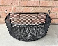 Front angle view of black metal bicycle basket showing mesh design and attachment hooks.