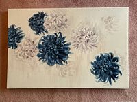 Viewing angle of blue and white floral painting on canvas, showing detailed flower brushstrokes and overall canvas condition