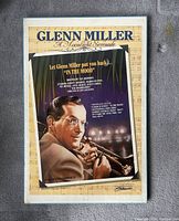 Photo showing the full front view of the Glenn Miller poster mounted on foam board lying on carpet, wrapped in plastic.