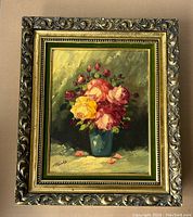 Full view of the signed floral oil painting in ornate gold frame, showing floral arrangement and signature.