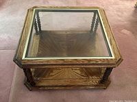 Top view of vintage wood and glass top coffee table with brass metal rim and visible wood stain fading.
