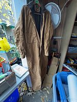 Full view of the brown men's winter coverall hanging, showing length and general condition.