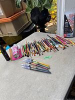 Overview of assorted artist paint brushes, ink brushes, and others laid out on a table.