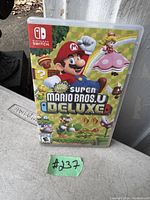 Front cover of the New Super Mario Bros. U Deluxe Nintendo Switch game case showing colorful artwork and game title.