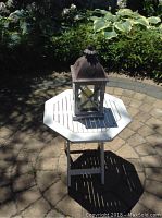 Outdoor white wooden octagonal table with decorative metal lantern on top