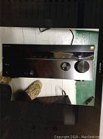 Front view showing brushed aluminum faceplate with two large knobs, display panel and input ports