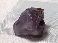 Close-up of the front side of the raw amethyst stone showing its deep purple color and natural crystal facets.