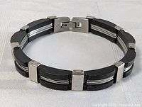 Bracelet full view showing the alternating onyx and stainless steel segments and the clasp.