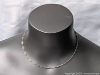 Front view of sterling silver twisted necklace on display stand, showing chain shape and texture.