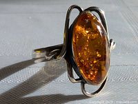 Close-up side view of vintage sterling silver ring highlighting the amber stone and silver swirl design