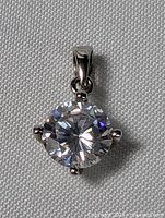 Close-up front view of the sterling silver pendant with clear crystal showing the prong setting and bail.