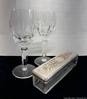 Two Waterford crystal wine glasses and the rectangular glass box with silver-tone ornate lid displayed against black background.