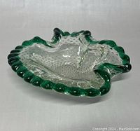 Top angled view of the clear, hand blown art glass bowl showing its green ruffled edge and textured dotted interior.
