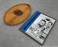 Photo showing both the handcrafted wooden tray and the Snoopy Peanuts mirror side by side on a gray surface.