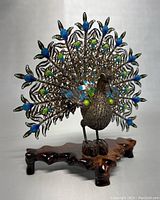 Front view of peacock figurine on wooden base