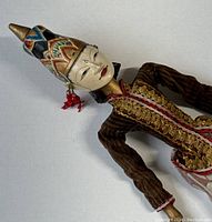 Side angle showing detailed face paint, headpiece, and embroidered outfit.