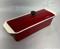 Full view of the red and cream rectangular cast iron casserole with lid on.