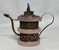 Front view of teapot showing brass body, jade bands, dragon reliefs and spout