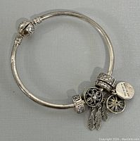 Full view of the Pandora silver bracelet with charms arranged on a neutral background to show the entire piece.