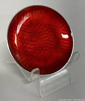 Front view of red guilloche enamel sterling silver small dish showing geometric pattern.