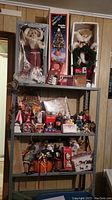 Wide view of entire Christmas decoration lot on shelves with dolls, boxes, figurines, and mugs visible