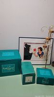 Overview of three teal Walt Disney Classics boxes, framed Snow White animation cel, and tall metal ornament stand with clear glass balls