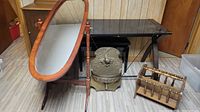 Full view of lot including wooden framed oval floor mirror, black metal desk, metal fountain piece with fish motif, and wooden magazine rack.