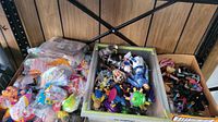 Overall view of the lot showing bins and zipped bags containing a mix of loose and packaged toys and figures.