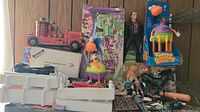 Overview of toy lot showing boxed model cars, Lego Friends set, Bumble Ball Bolters toy, action figures, and miscellaneous smaller toys