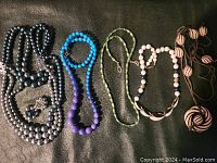 Overview of all six bead necklaces displayed on a black background