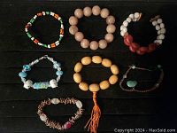 Seven pairs of bracelets shown arranged in two rows, showcasing different bead styles and types.