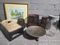 Photo showing all items in the lot including framed watercolor, tissue box holder, three candle holders, mason jar, and metal candle plate.