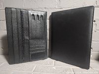 Two black leather A4 document holders, one open showing interior compartments, the other closed
