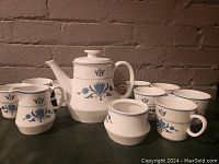 Full tea set including teapot, 8 cups, creamer, and sugar bowl in Blue Haven pattern on white porcelain