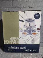 Photo of the unopened box showing branding and set information for stainless steel fondue set 28 pieces.