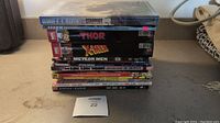 Stack of comic and graphic novels showing titles and condition