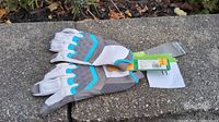 Pair of new bike gloves lying on concrete surface, showing top and palm sides, with original tags attached indicating size 11.