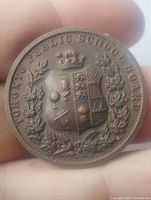Obverse side of the bronze medal showing the crowned shield with school symbols and laurel wreath with 'Toronto Public Schools Board' inscription.