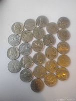 Overview of 30 old US and Canadian 5 cent coins, laid out in a few rows on white surface, showing various obverse and reverse designs including Jefferson and beaver.