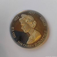 Obverse side of the silver coin featuring Queen Elizabeth II profile with inscriptions for Silver Jubilee 1952-1977.