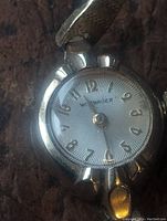 Close-up front view of Whitnaur women's watch dial and case, showing brand name and gold-filled case.