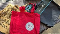 Three tote bags laid out showing overall view and logos