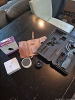 Group shot: Netgear adapter box, leather pouch, DJI Osmo Mobile 2 gimbal in foam, Echo Dot, AirPods box corners visible