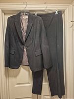 Front view of blazer and trousers on hangers