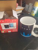 Friends heat-changing mug in retail box next to mug