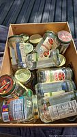 Cardboard box containing multiple empty glass jars with lids